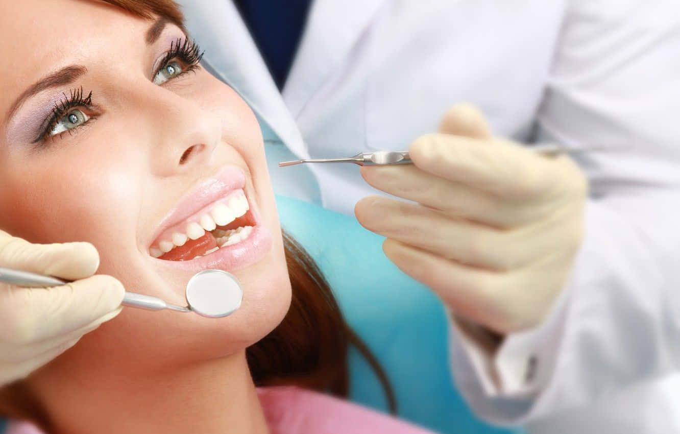 Undentista E Un Assistente Dentale Dedicati Lavorano Insieme Per Migliorare Il Sorriso Di Un Paziente.