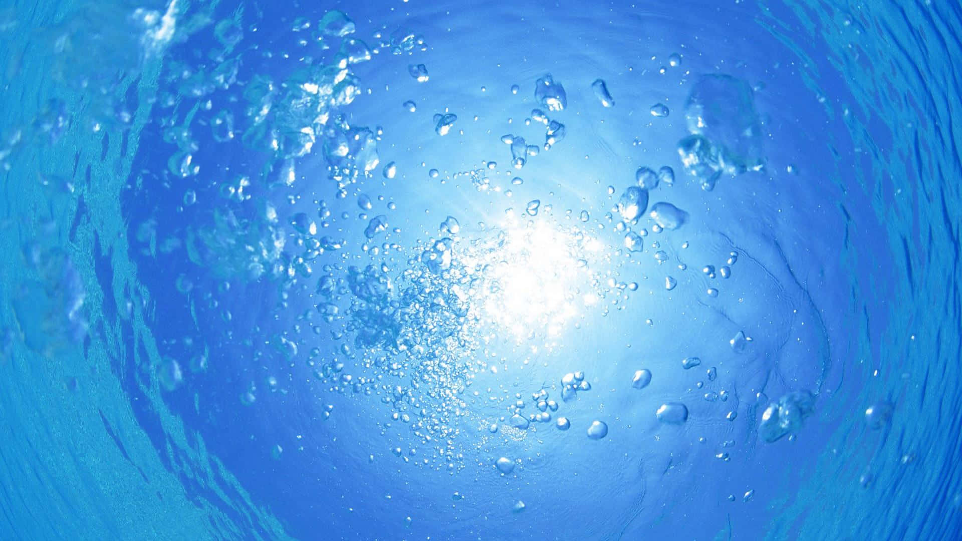 A Blue Water Surface With Bubbles And Bubbles