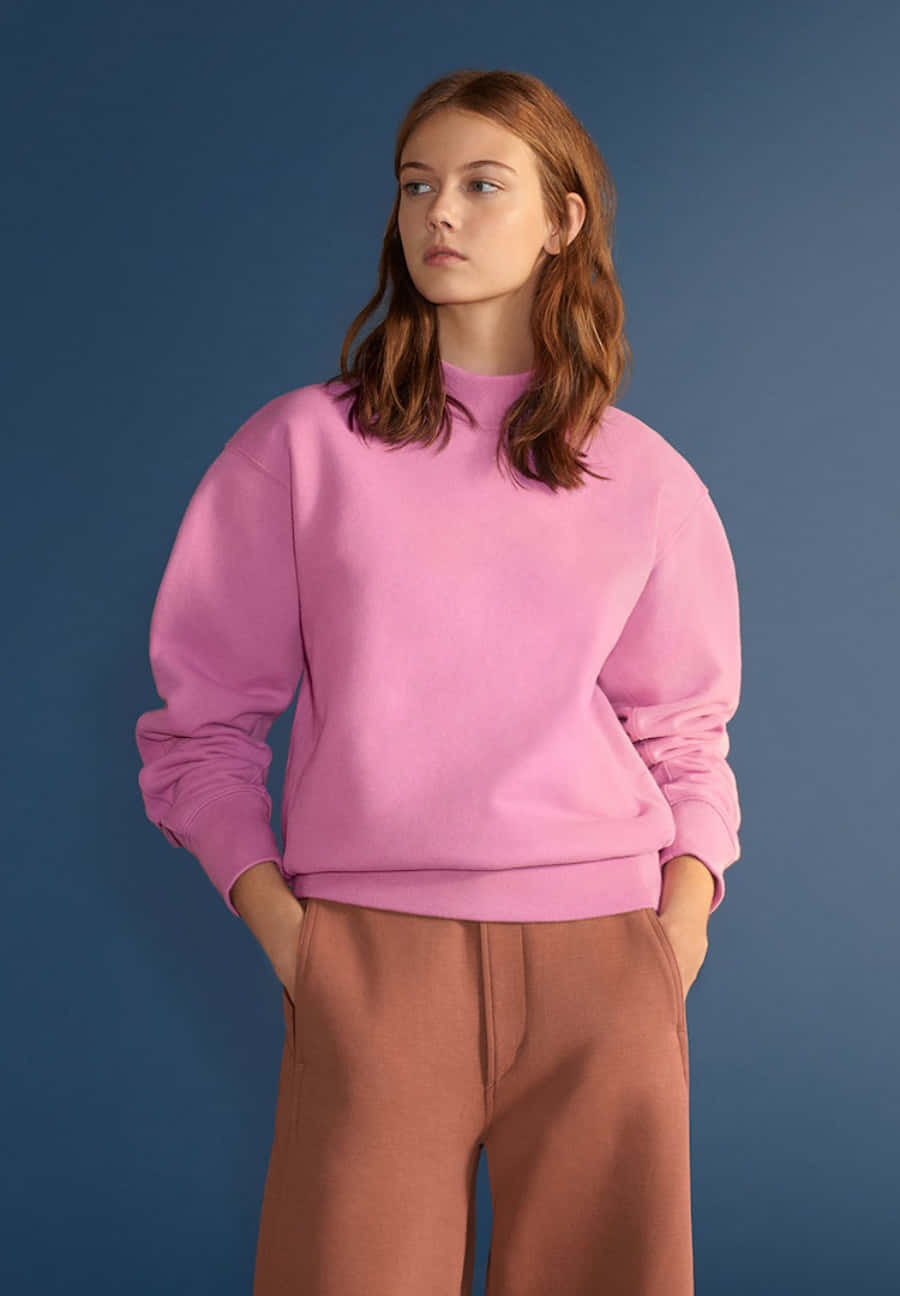 A Model Wearing A Pink Sweatshirt And Brown Trousers