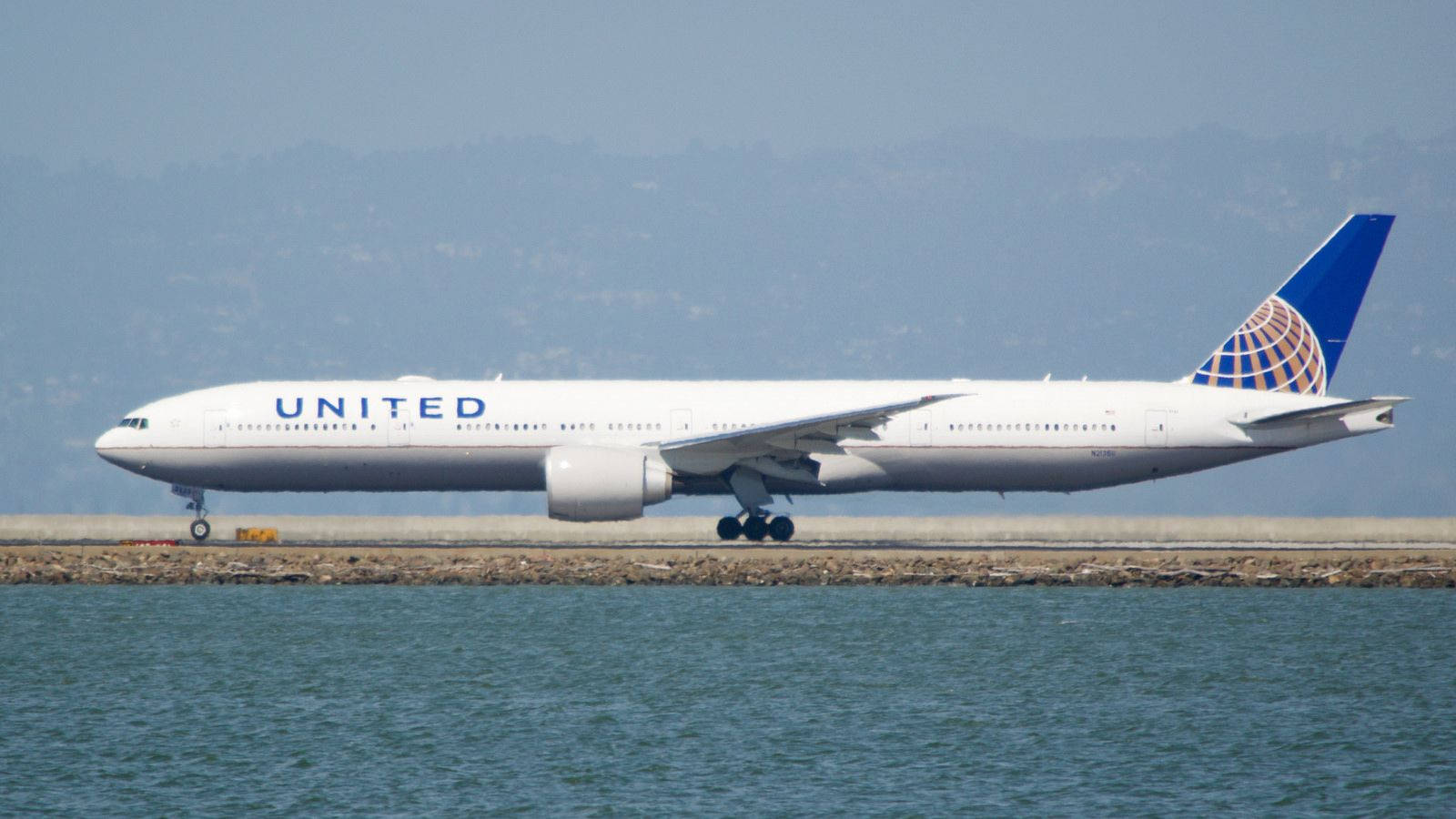 Aviónde United Airlines En Una Pista De Océano. Fondo de pantalla