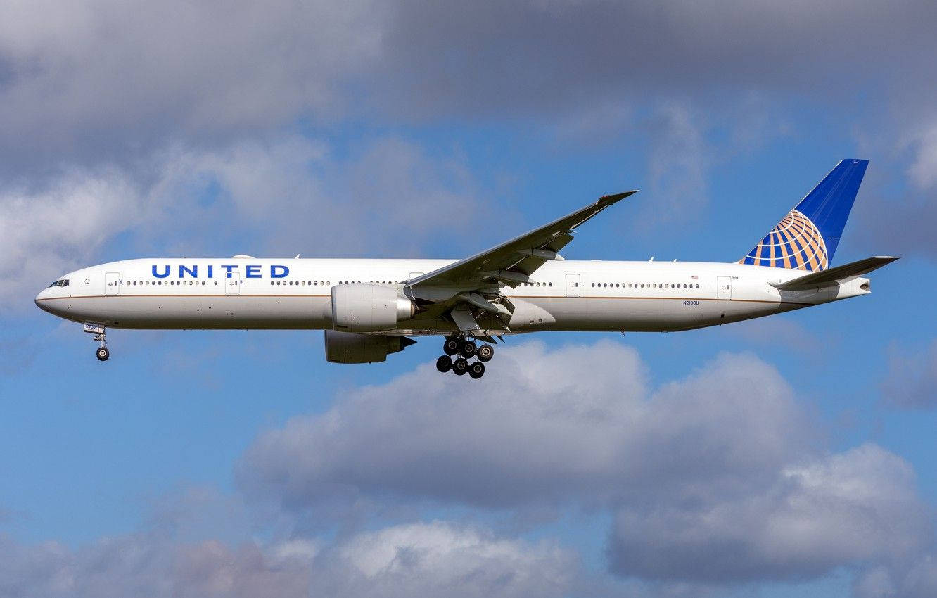 United Airplane Soaring Against Cloudy Sky Background