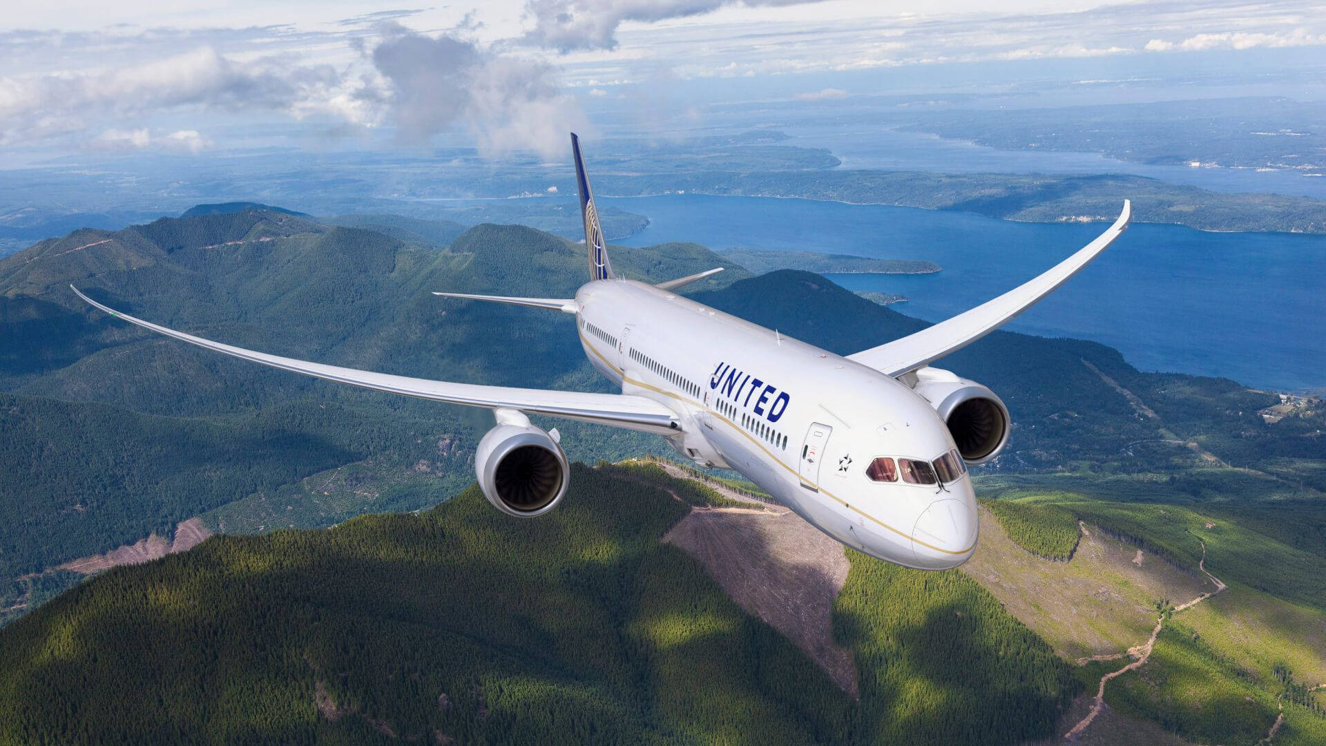 United Airplane Soaring Over High Mountains Wallpaper