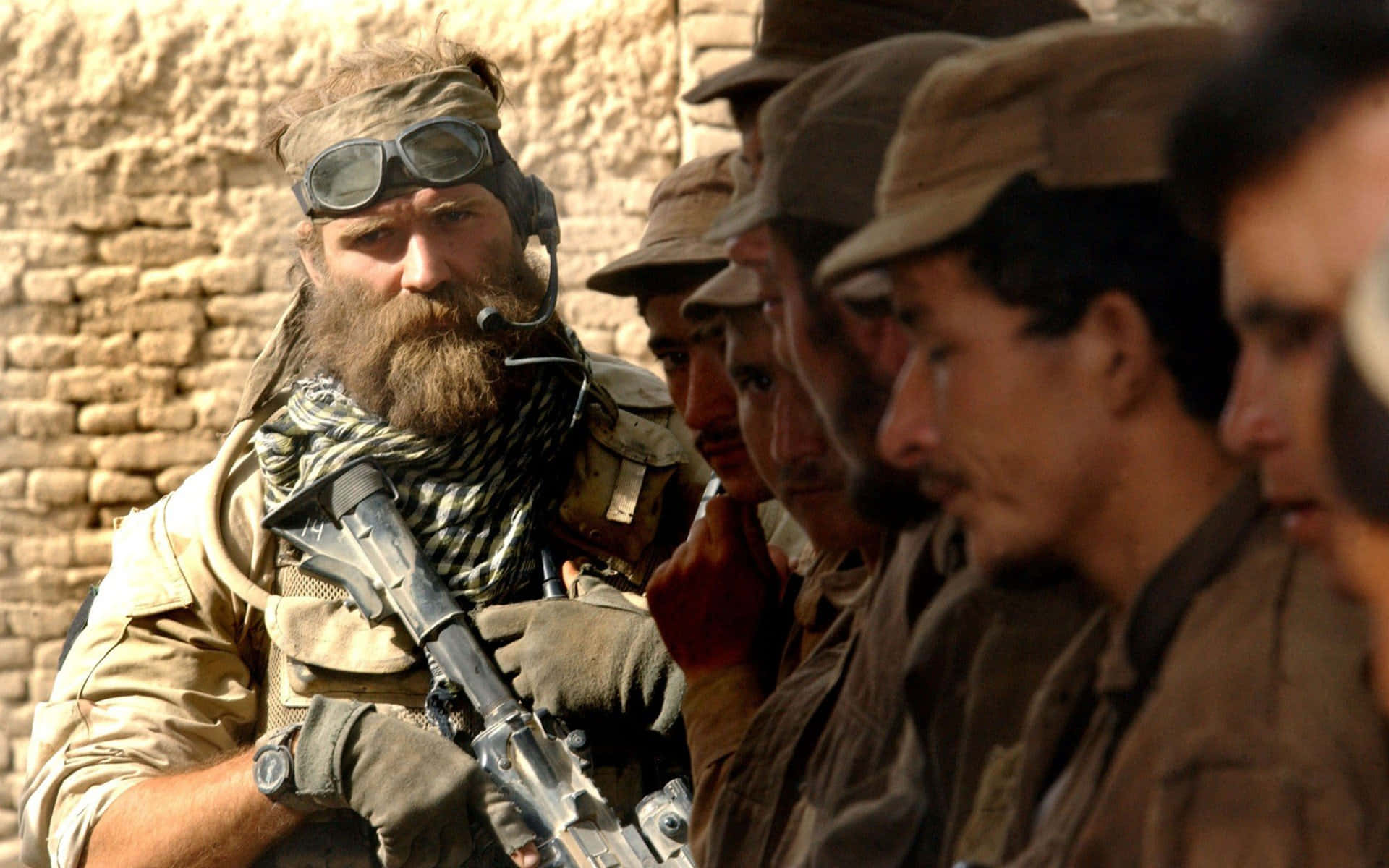 En soldat med et gevær foran en gruppe mænd Wallpaper