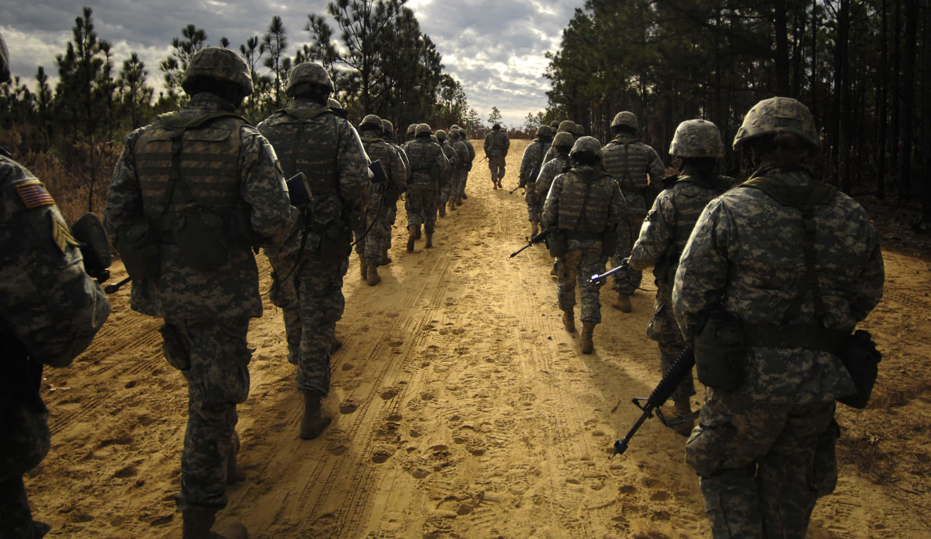 Ungrupo De Soldados Caminando Por Un Camino De Tierra Fondo de pantalla