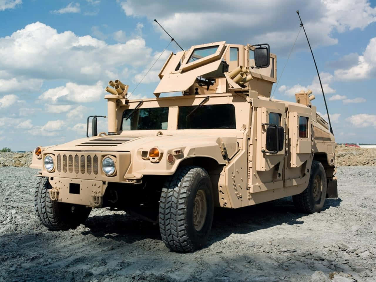 Et militærkøretøj er parkeret på en grusvej. Wallpaper