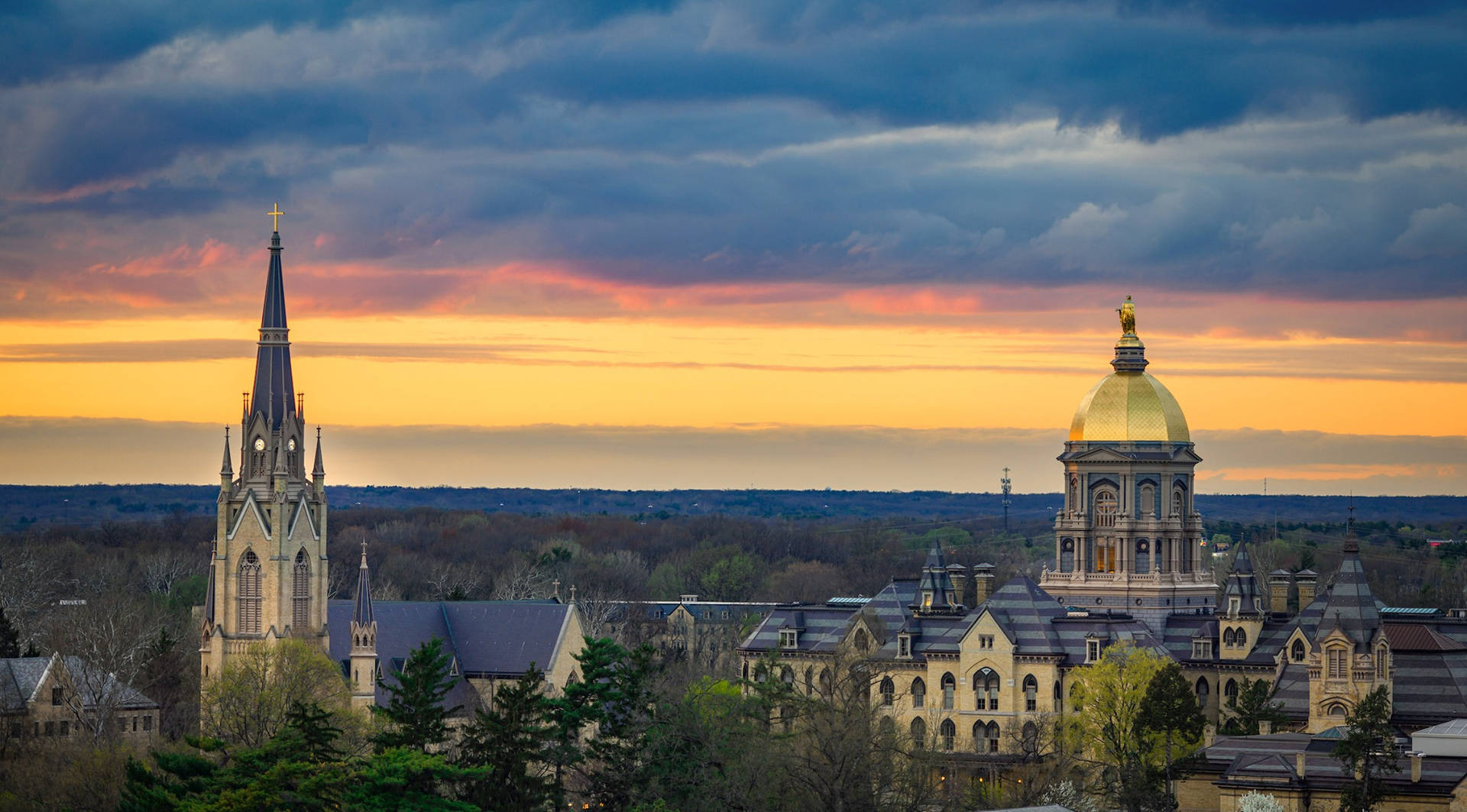 Bygninger på University of Notre Dame under solnedgangsskyen Wallpaper