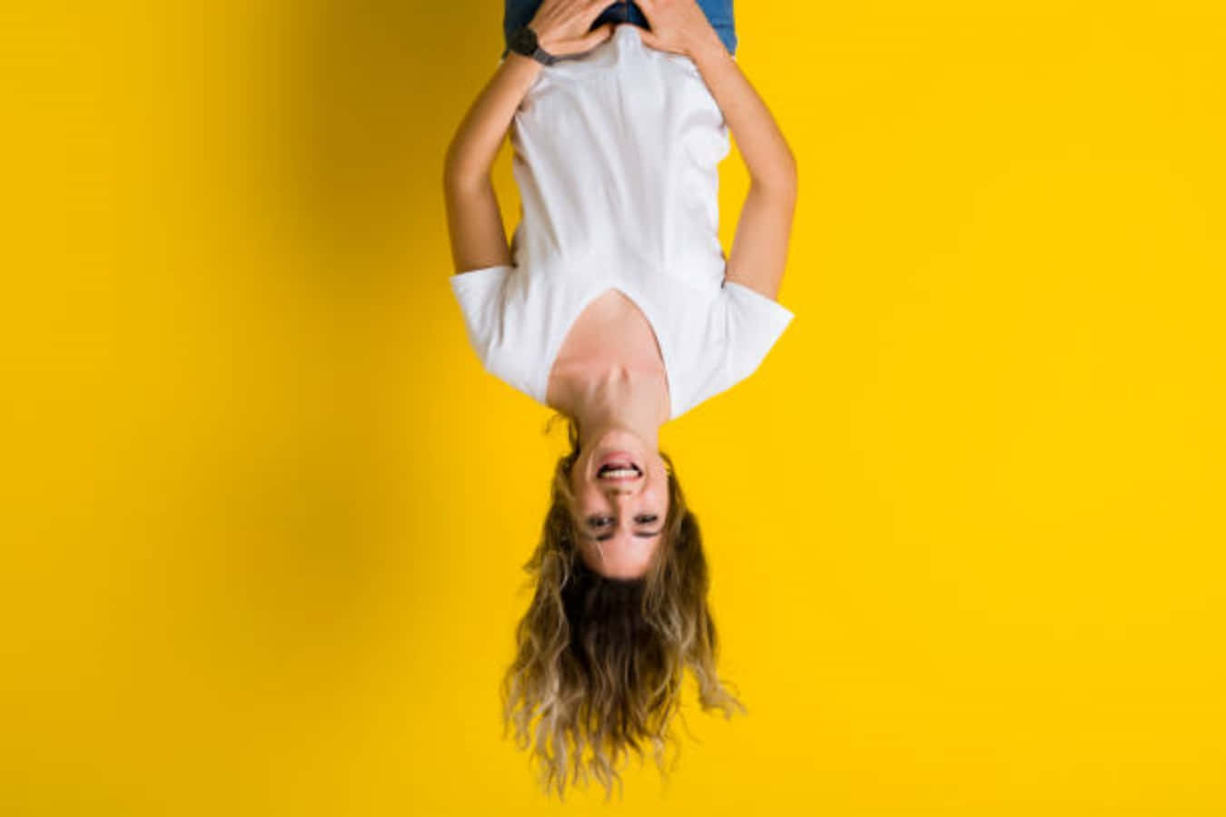 A Woman Is Upside Down On A Yellow Background