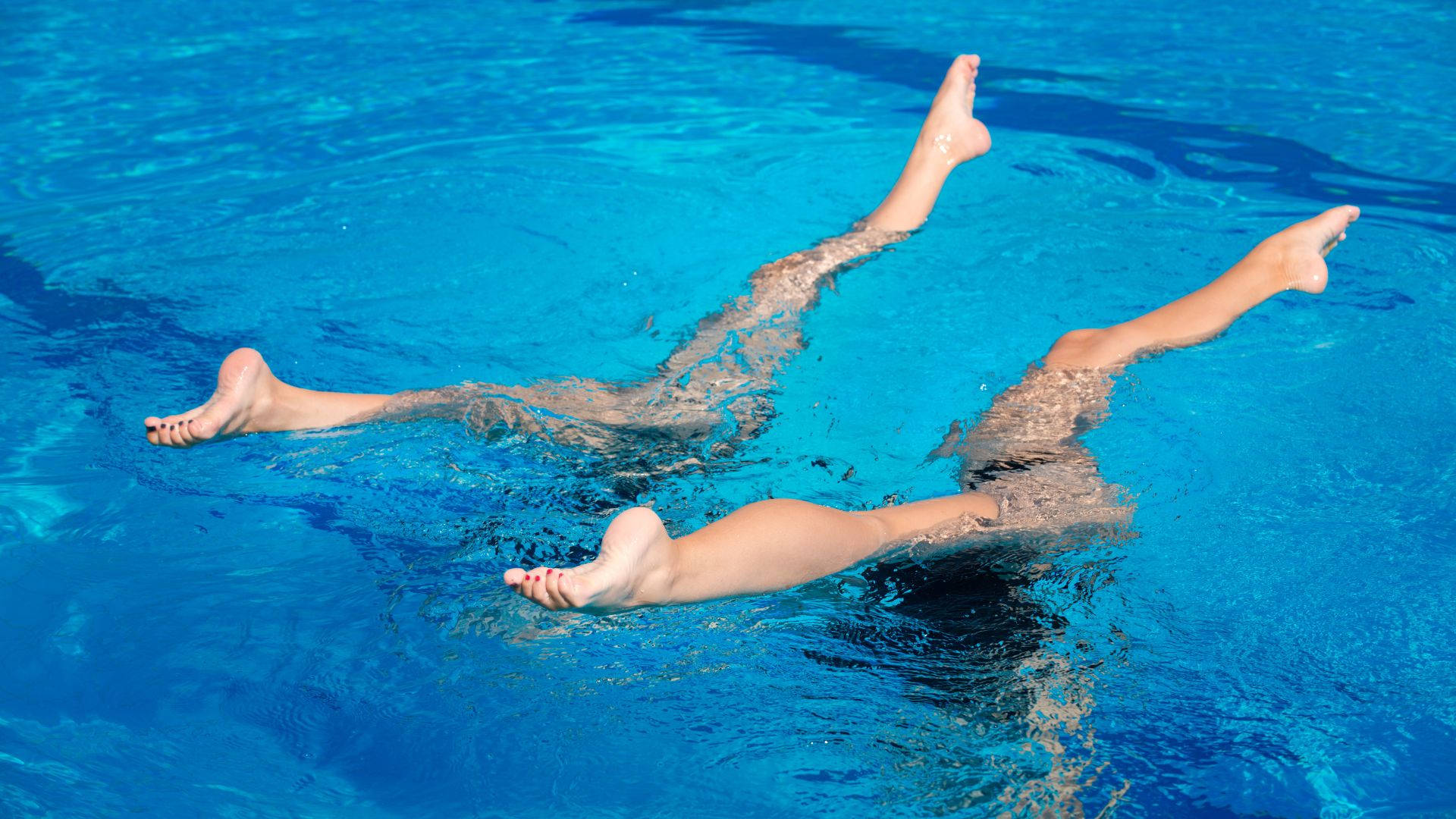 "An Artistic Swimmer Performs an Upside-Down Split Underwater" Wallpaper