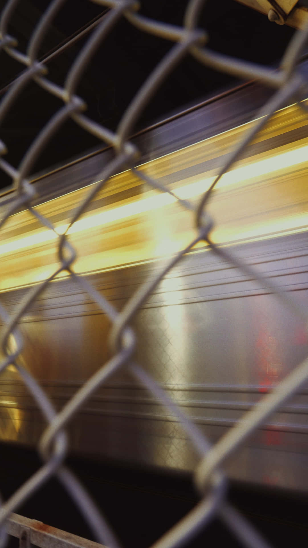 Urban Speed Blur Behind Chainlink Fence Wallpaper
