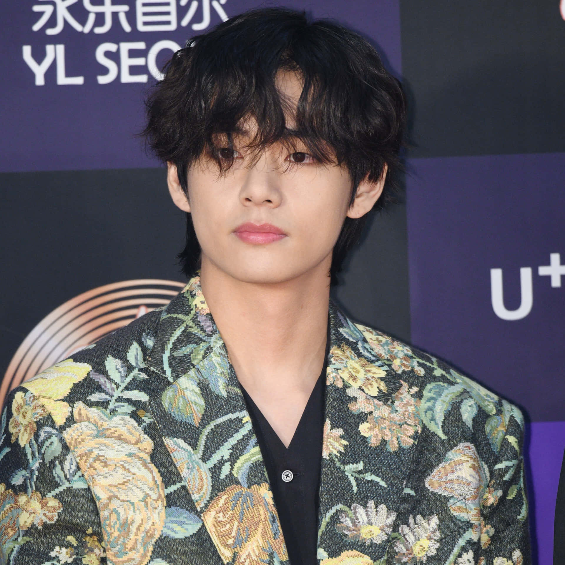 A Young Man In A Floral Jacket Is Standing On The Red Carpet