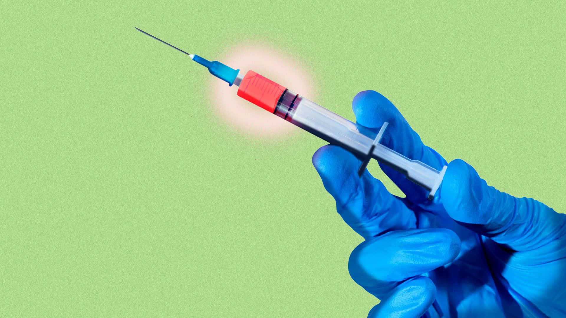 A hand holding a syringe and vaccine vial against a bright background.