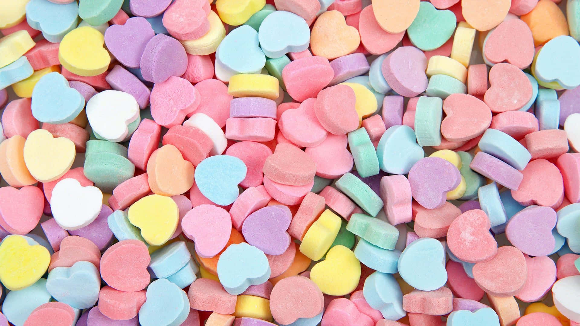 A Pile Of Candy Hearts In Different Colors