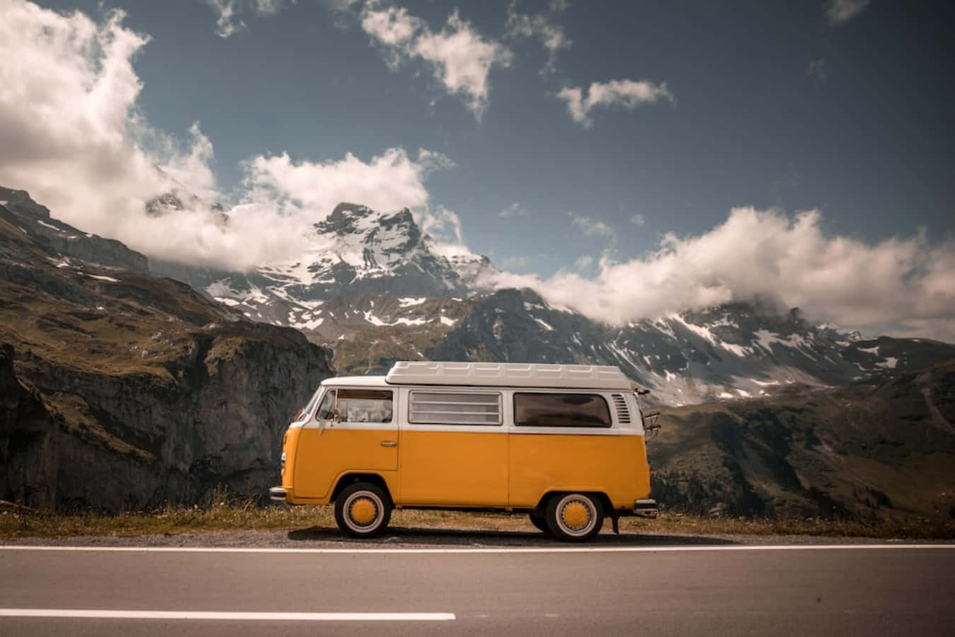 A Yellow Vw Bus Parked On The Side Of The Road