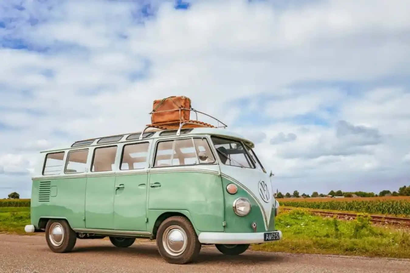 A Green Vw Bus With Luggage On The Road