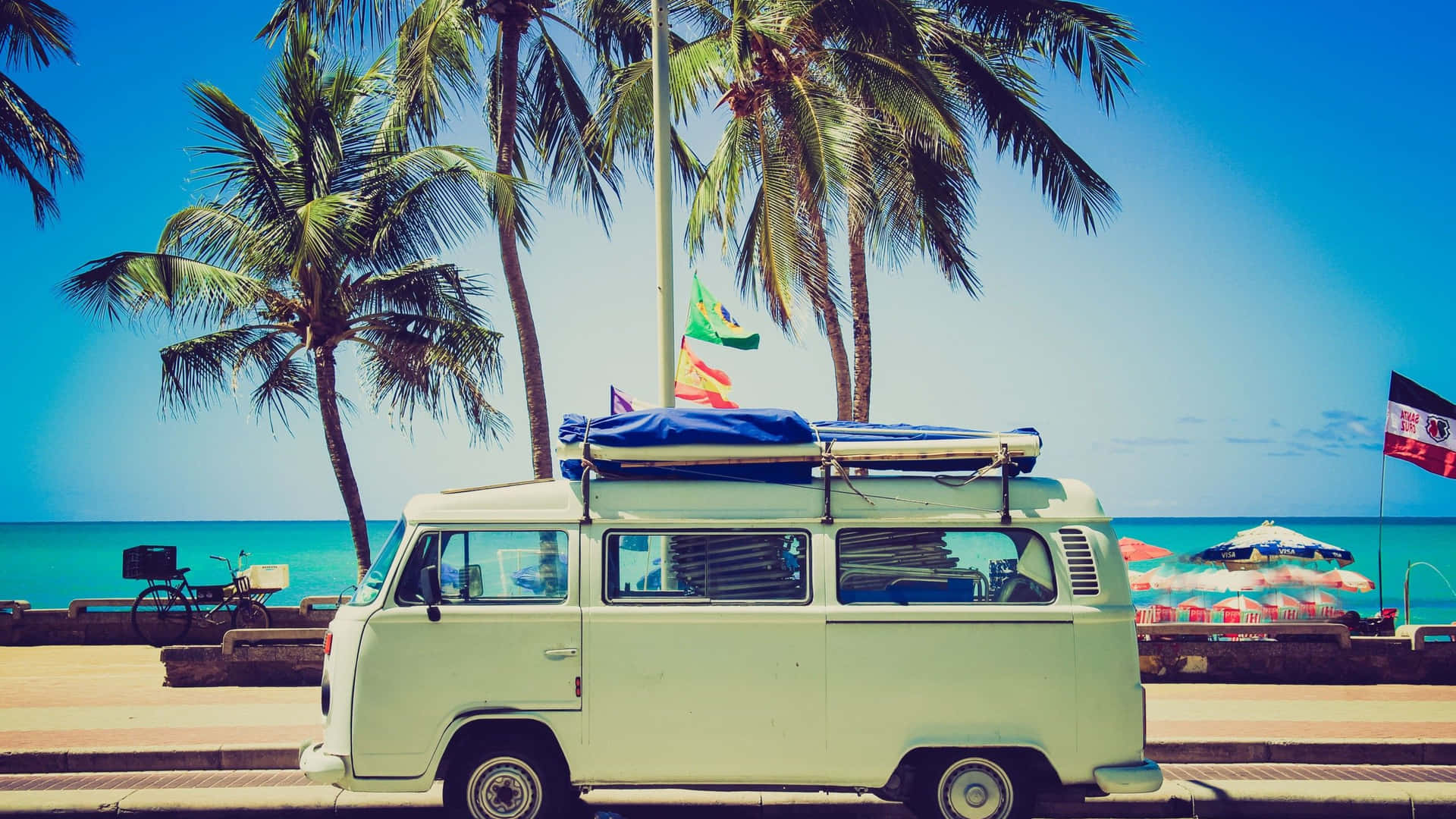 A Vw Bus Parked On The Beach With Palm Trees