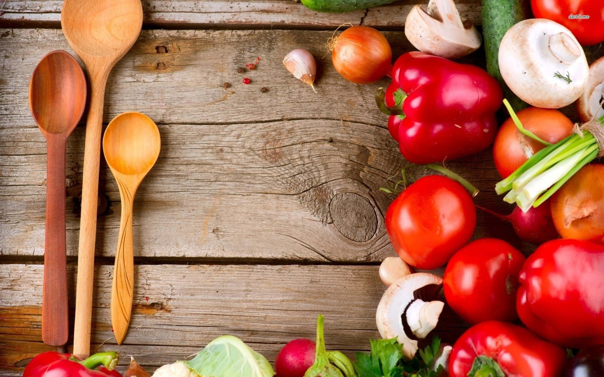 A Wooden Spoon And Vegetables On A Wooden Table