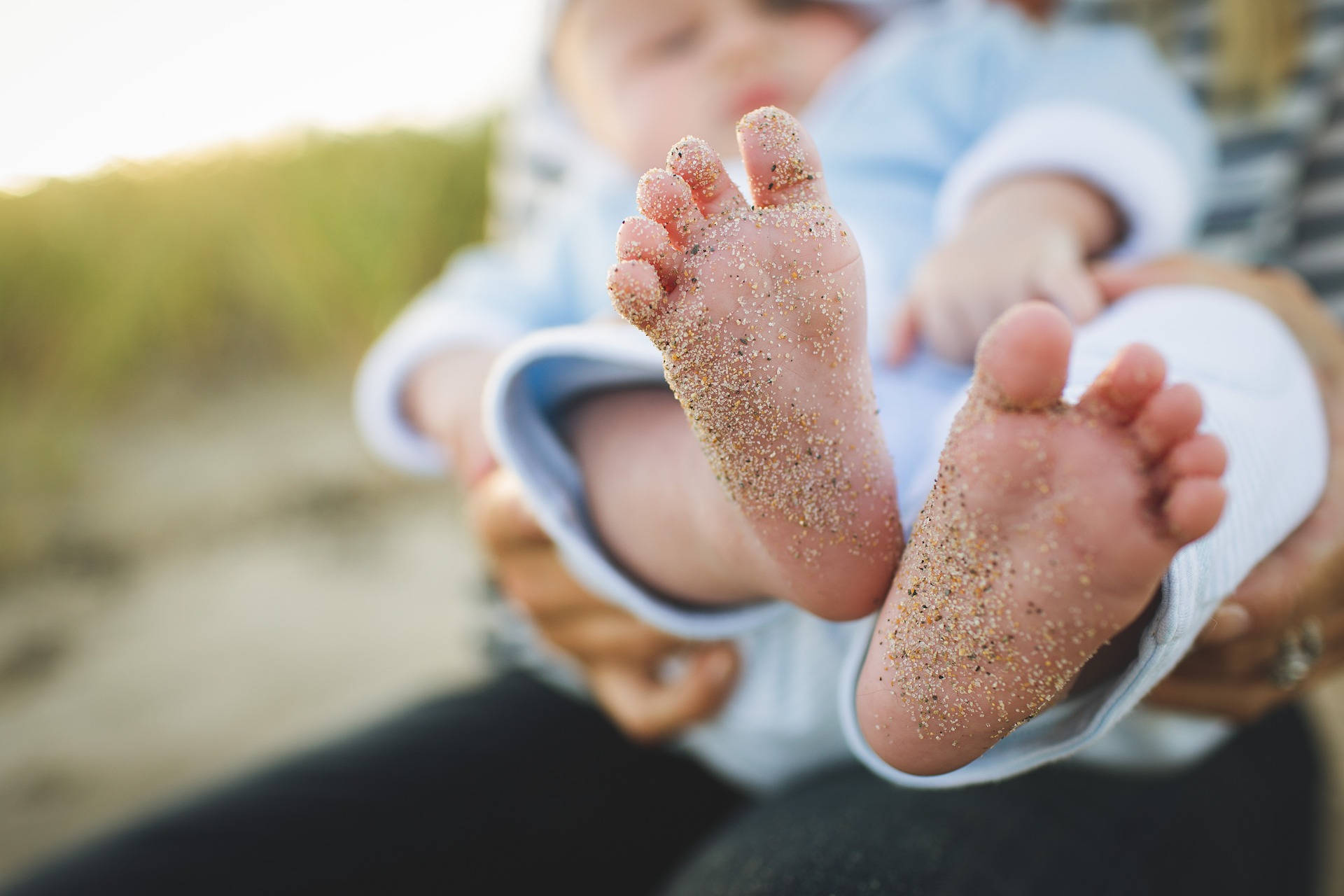 Meget søde babyfødder med sandaler på et hvidt baggrund. Wallpaper