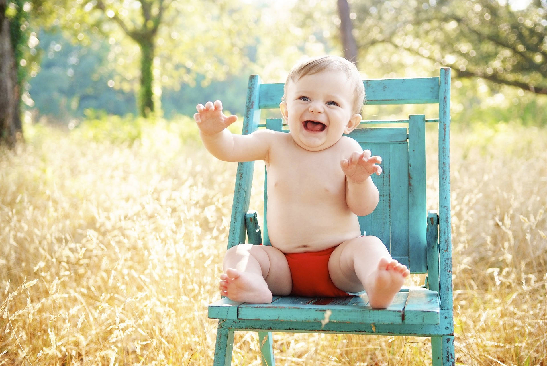 Sehrsüßes Baby Lacht Auf Einem Stuhl. Wallpaper