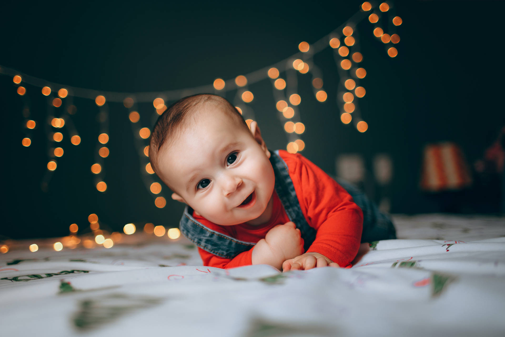 Very Cute Baby With Christmas Lights Wallpaper