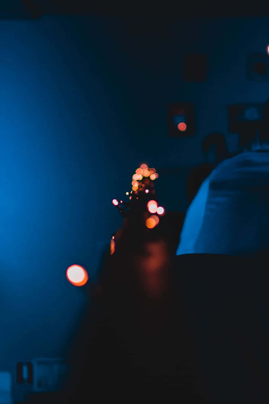 Eineperson Sitzt In Einem Dunklen Raum Mit Eingeschalteten Lichtern.
