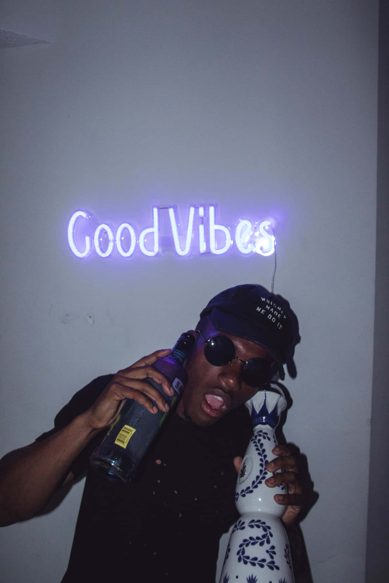 A Man Holding A Bottle Of Wine And A Sign That Says Good Vibes