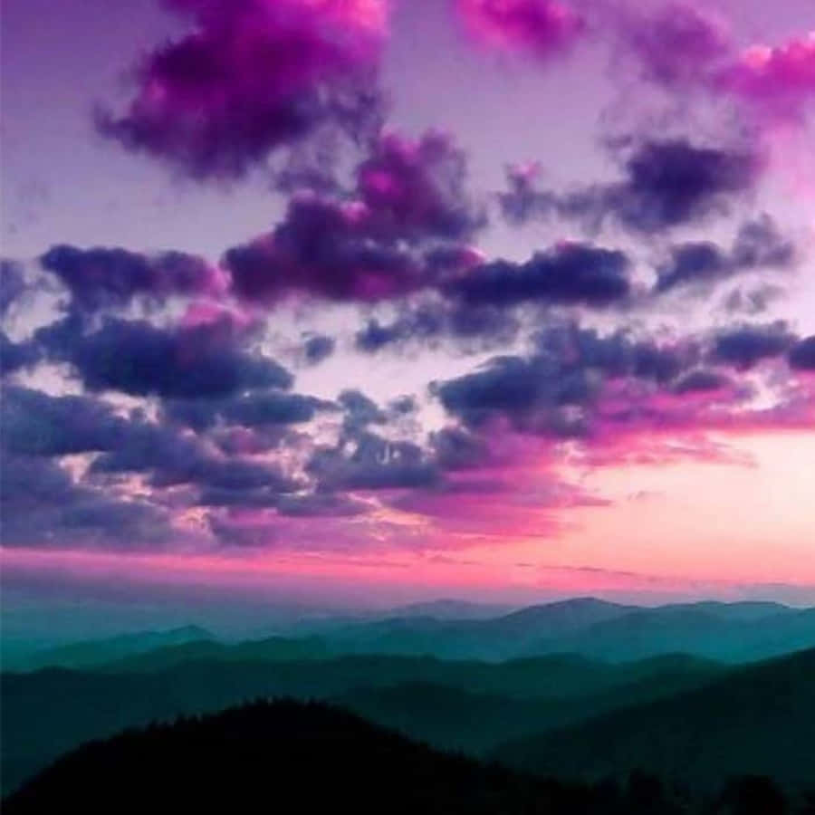 A Purple Sky With Clouds Over Mountains