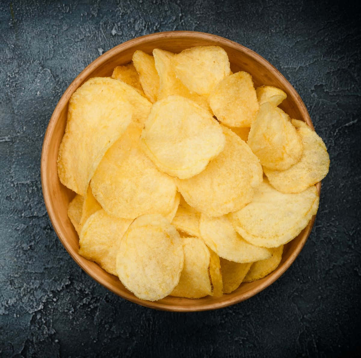 Vibrant Potato Chips against a Black Background Wallpaper