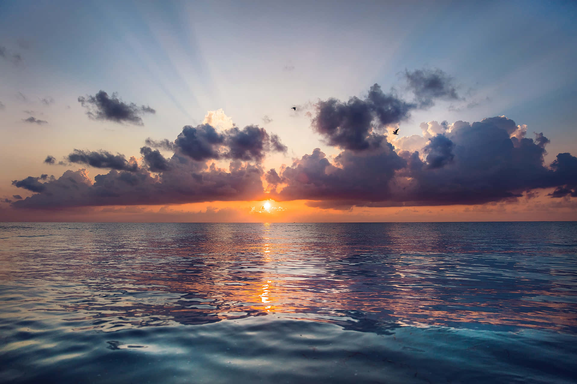 sunset over the ocean with clouds and water Wallpaper