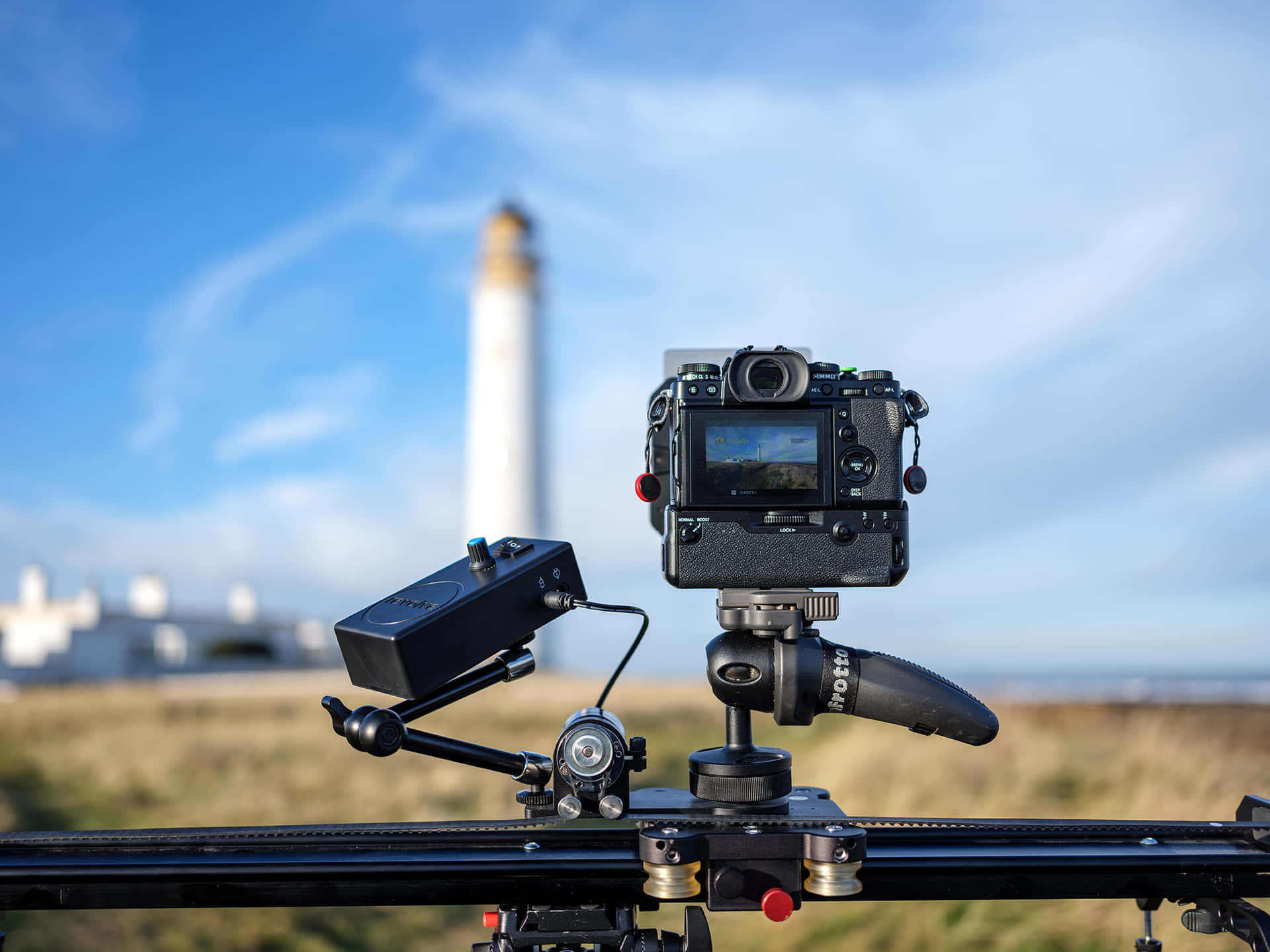 A Camera Is Sitting On A Tripod In Front Of A Lighthouse