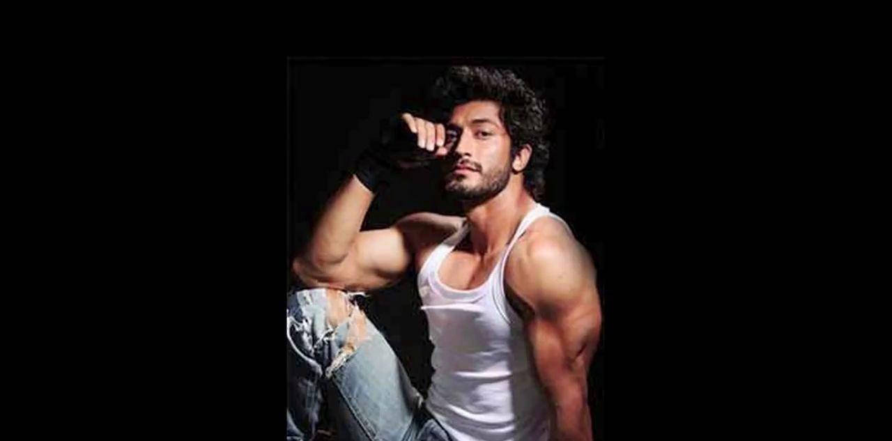 Fitness Icon Vidyut Jamwal Showcasing His Well-Defined Physique Against a Black Background Wallpaper