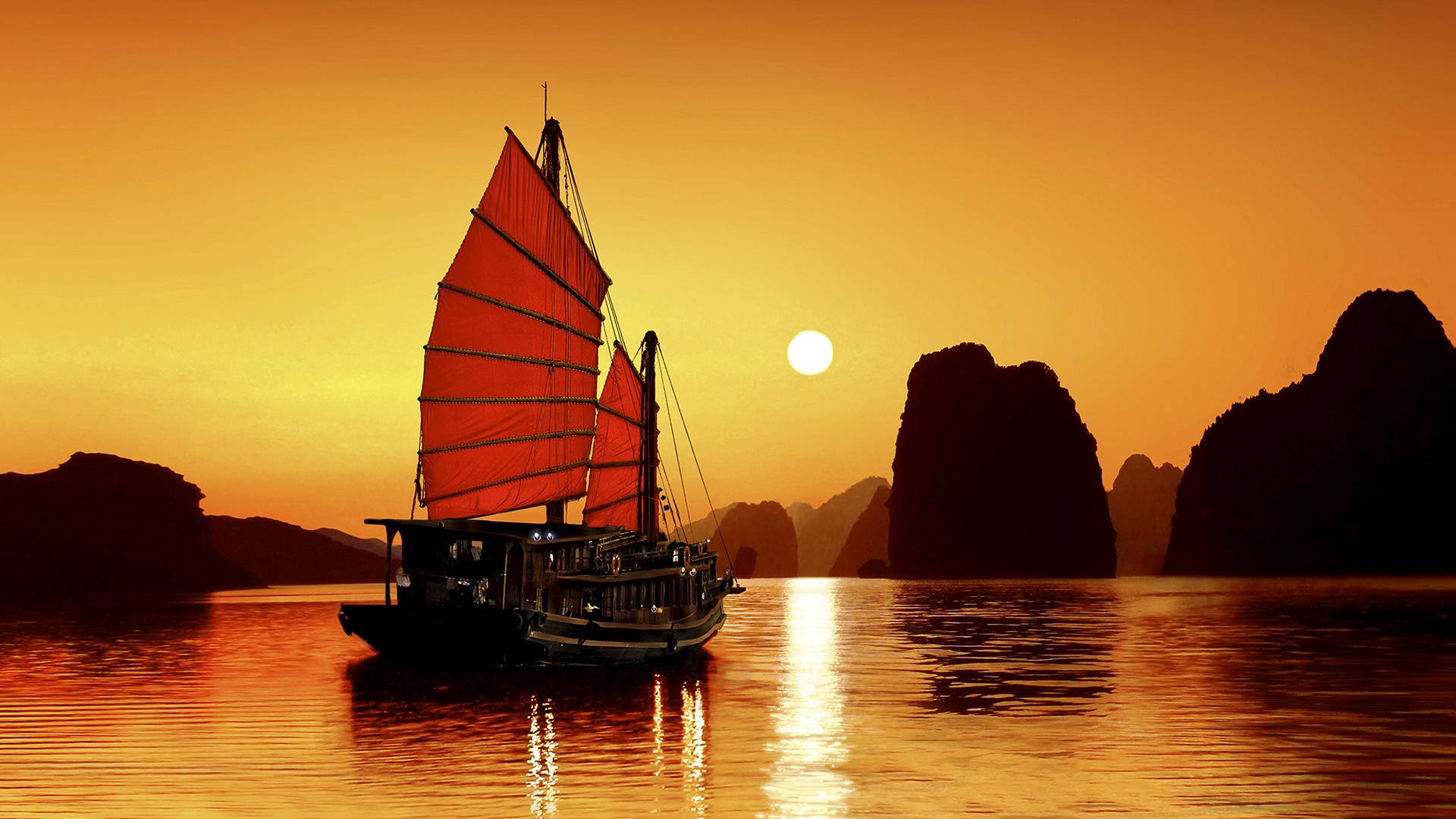 Traditional Vietnamese Junk Boat Cruising on Tranquil Waters Wallpaper