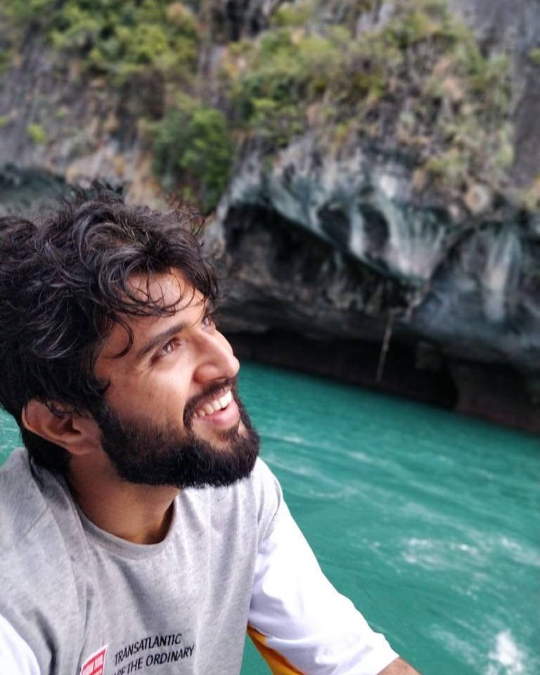 Vijay Deverakonda smiler på en strand 4K tapet Wallpaper