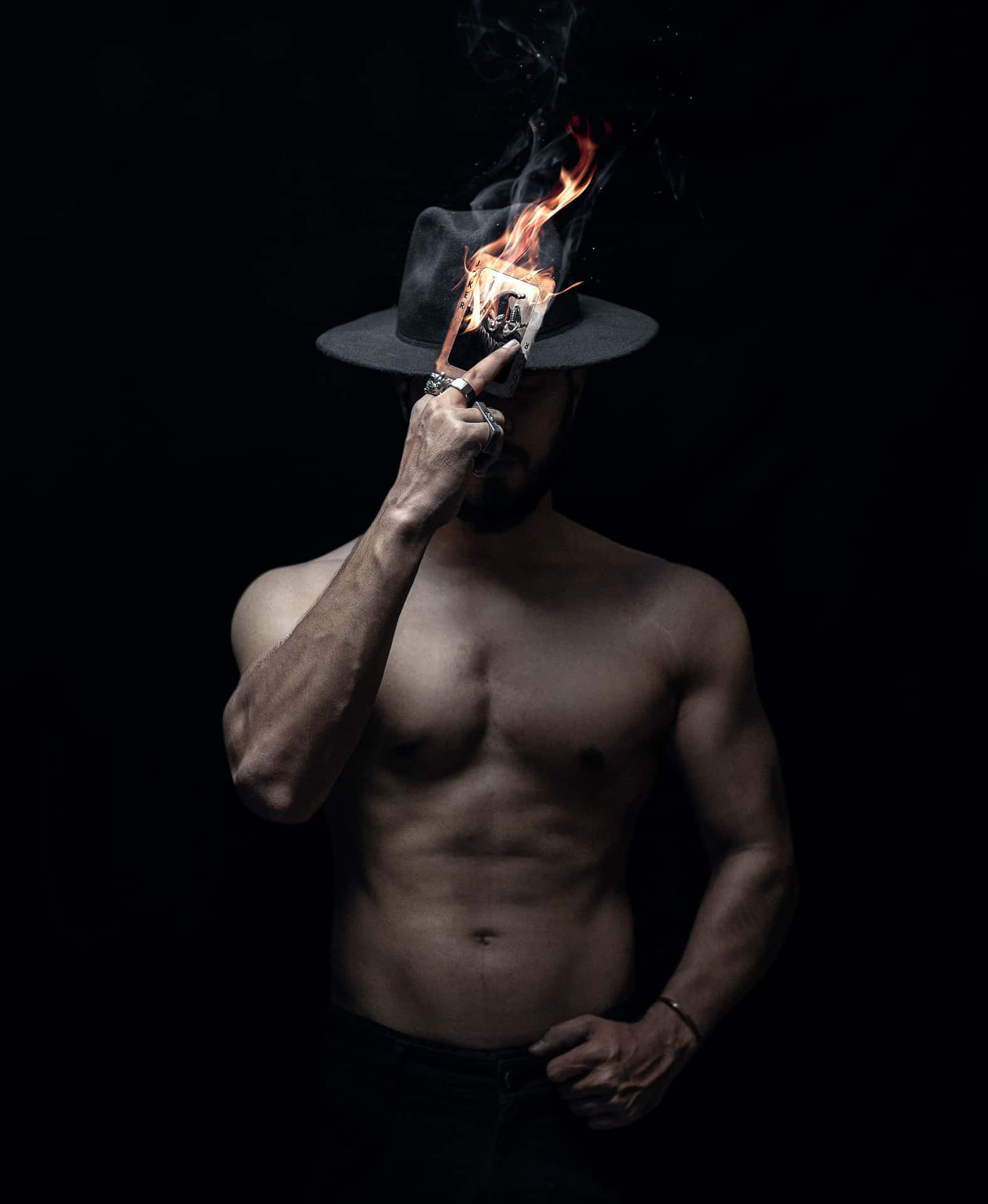 A Man In A Hat Holding A Fire