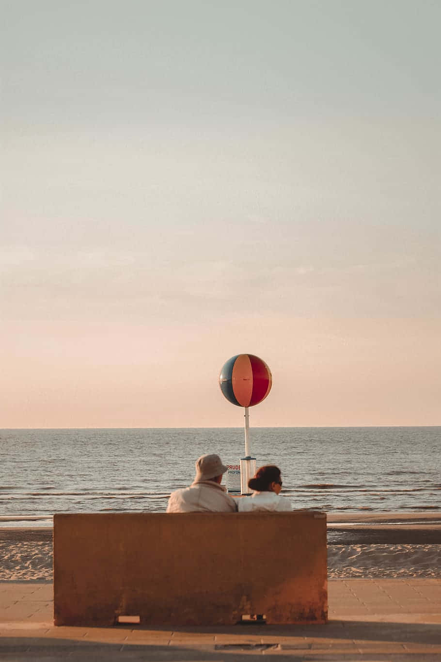 Vintage Beach Sunset With Coupleand Beach Ball Wallpaper