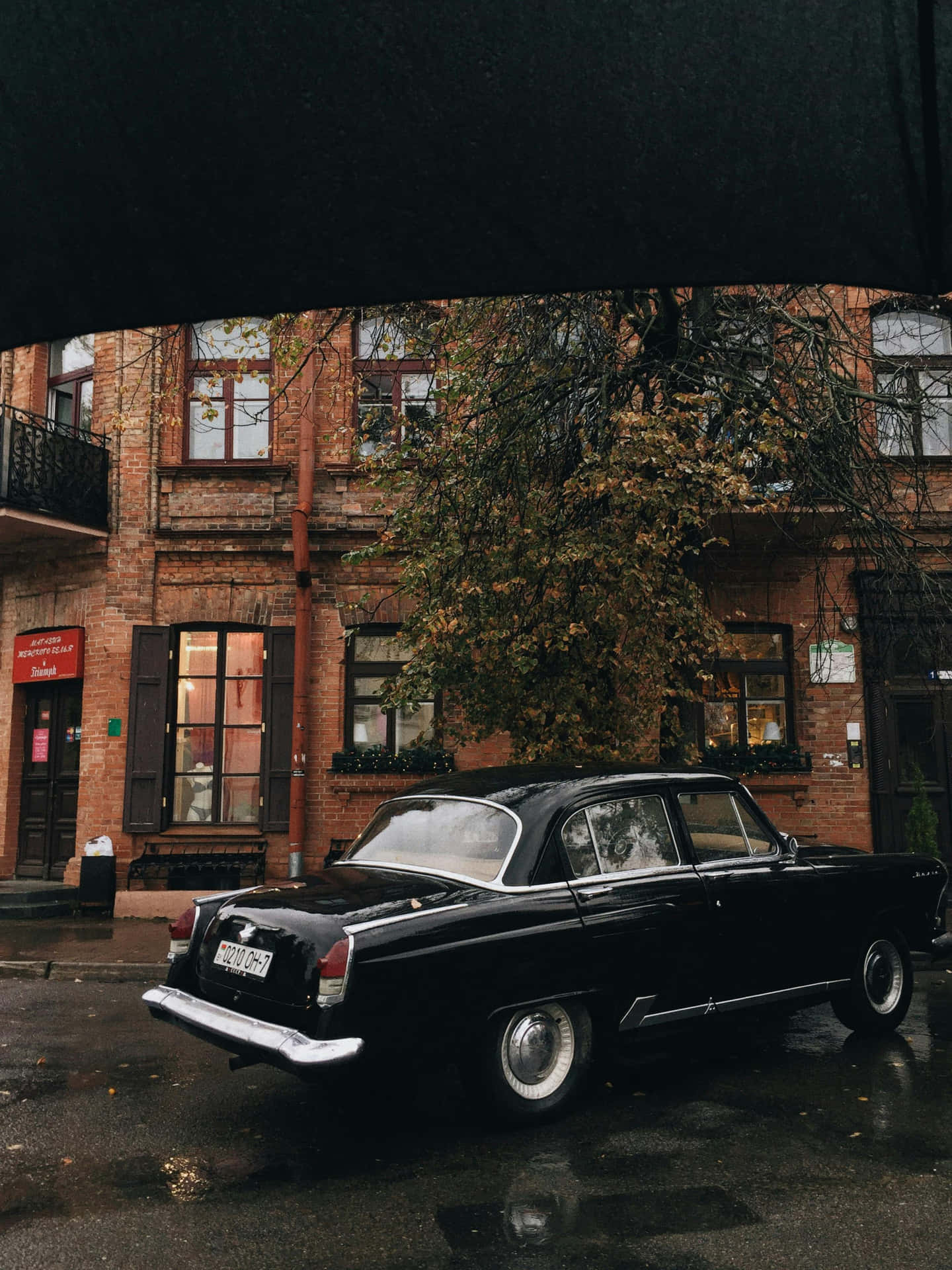 Vintage Black Car Rainy Street Scene Wallpaper