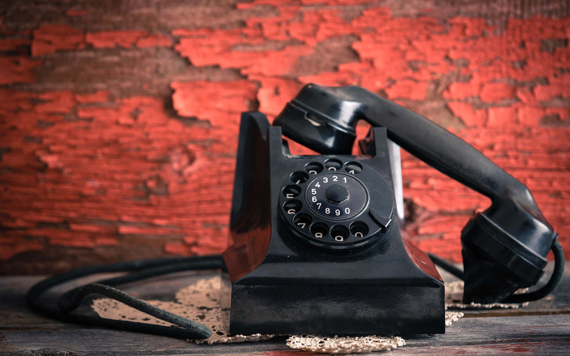 Vintage Black Rotary Phoneon Red Background Wallpaper