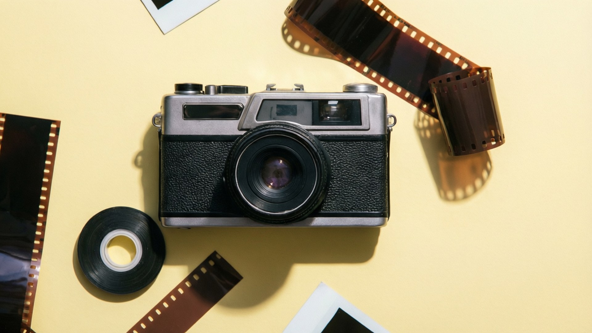 En pastellgul bakgrunn med flytende vintagekamera- og film-PNG-er, Tumblr-estetikk.