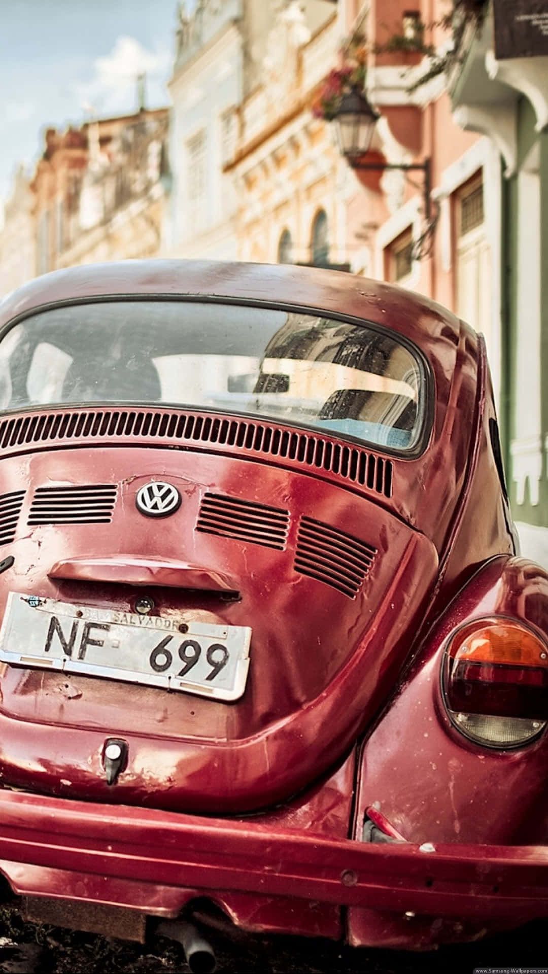A Red Volkswagen Beetle Parked On A Street Wallpaper