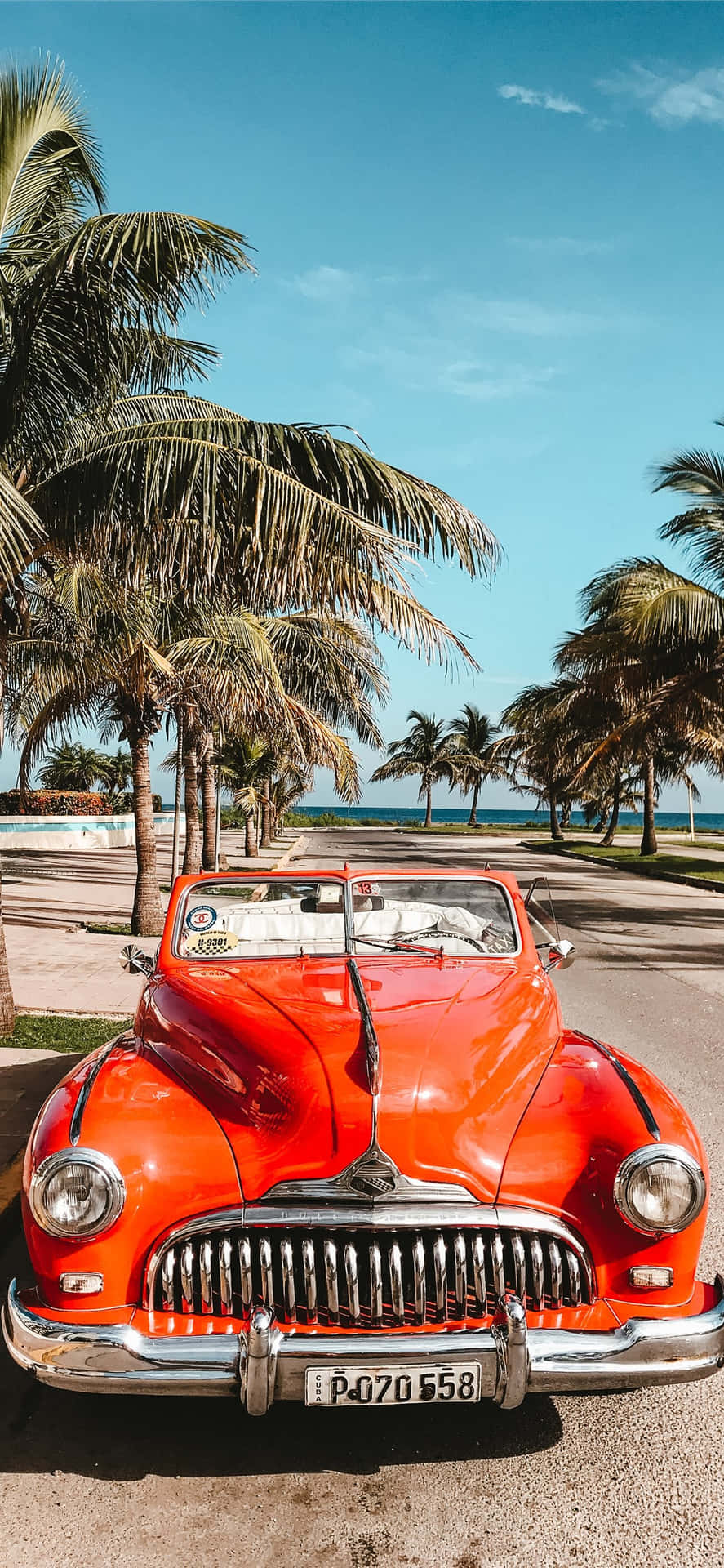 An Orange Classic Car Parked On The Beach Wallpaper