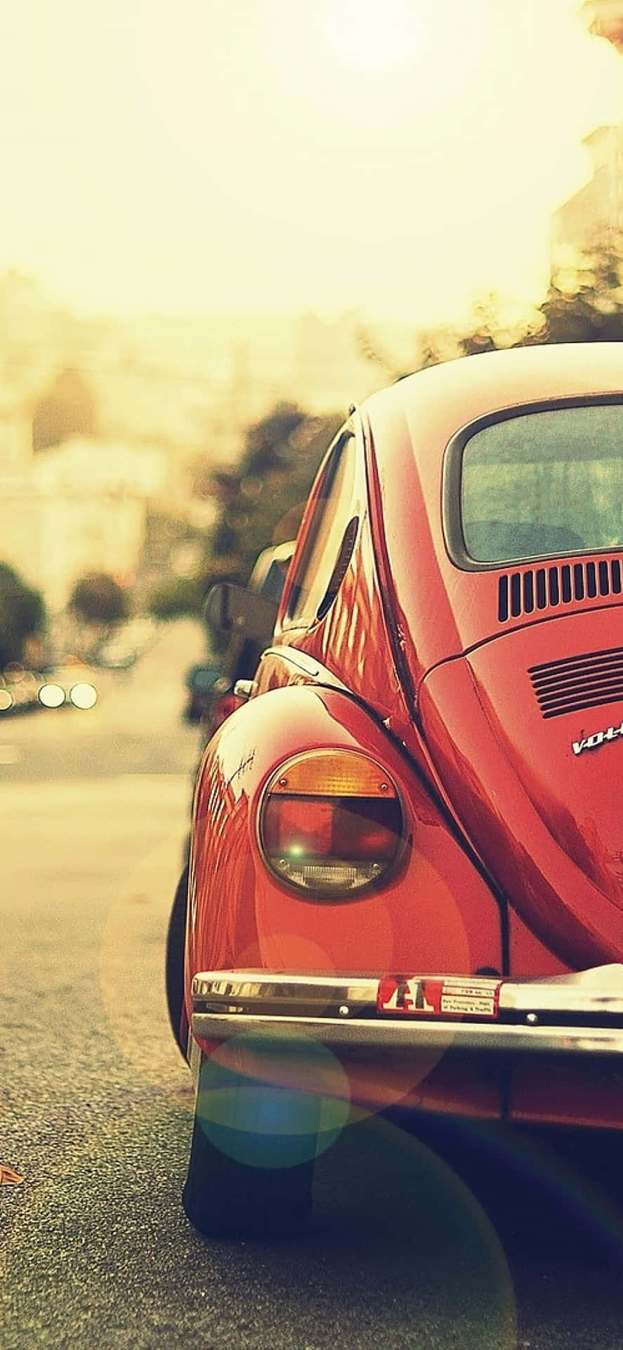 En rød Volkswagen bille parkeret på gaden. Wallpaper