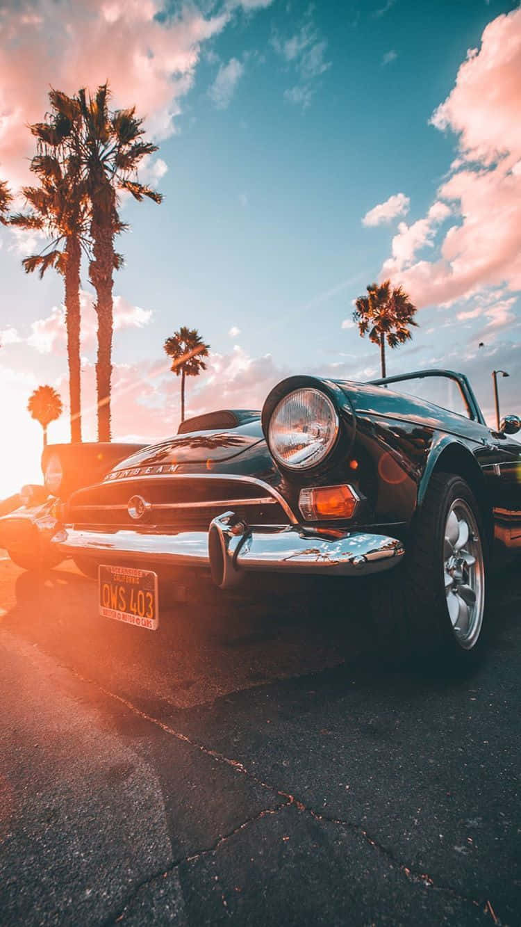 A Spectacular Vintage Car Sitting Next To An Iphone Wallpaper