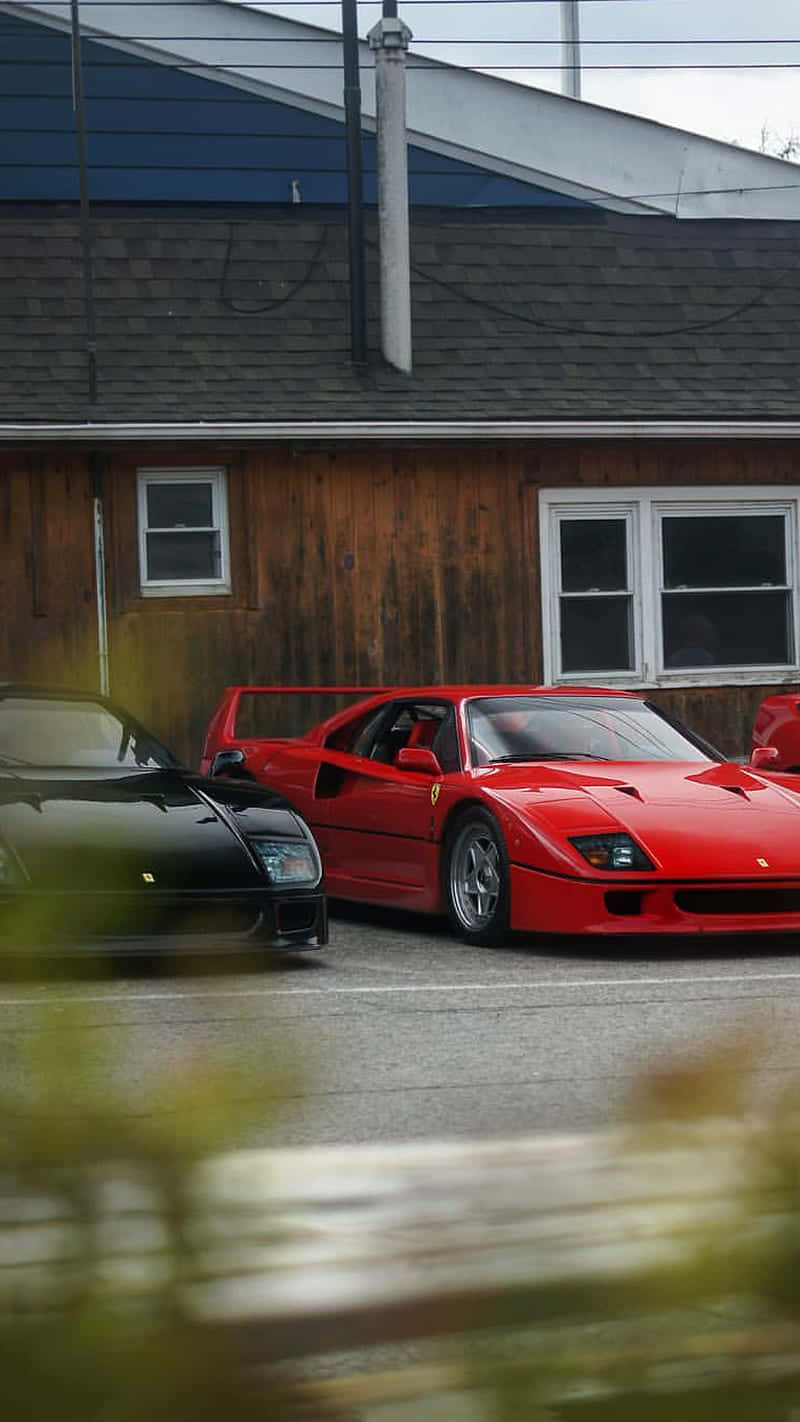 En gruppe af røde sportsbiler parkeret foran et bygning Wallpaper
