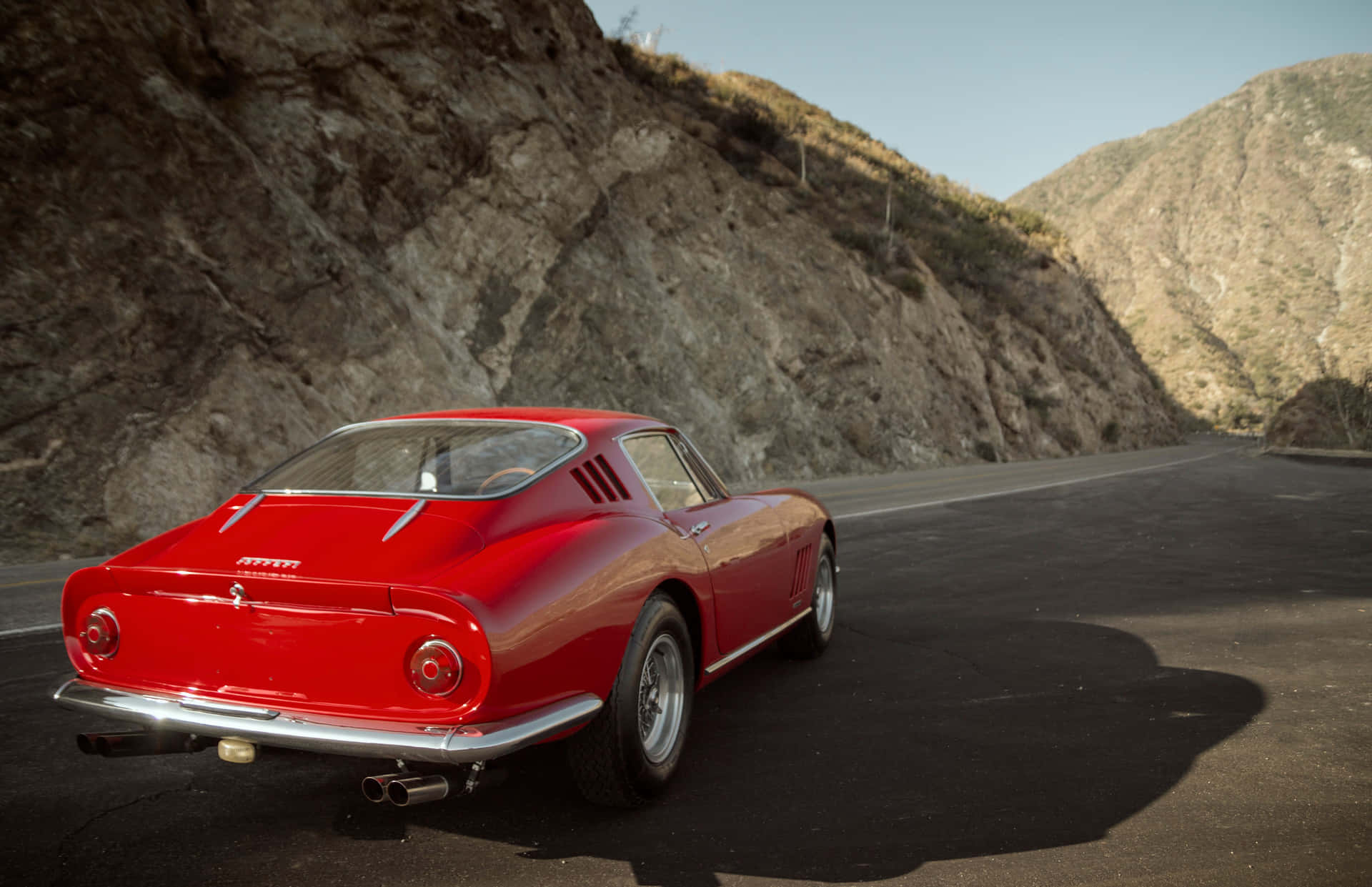 A Red Sports Car Is Parked On A Mountain Road Wallpaper