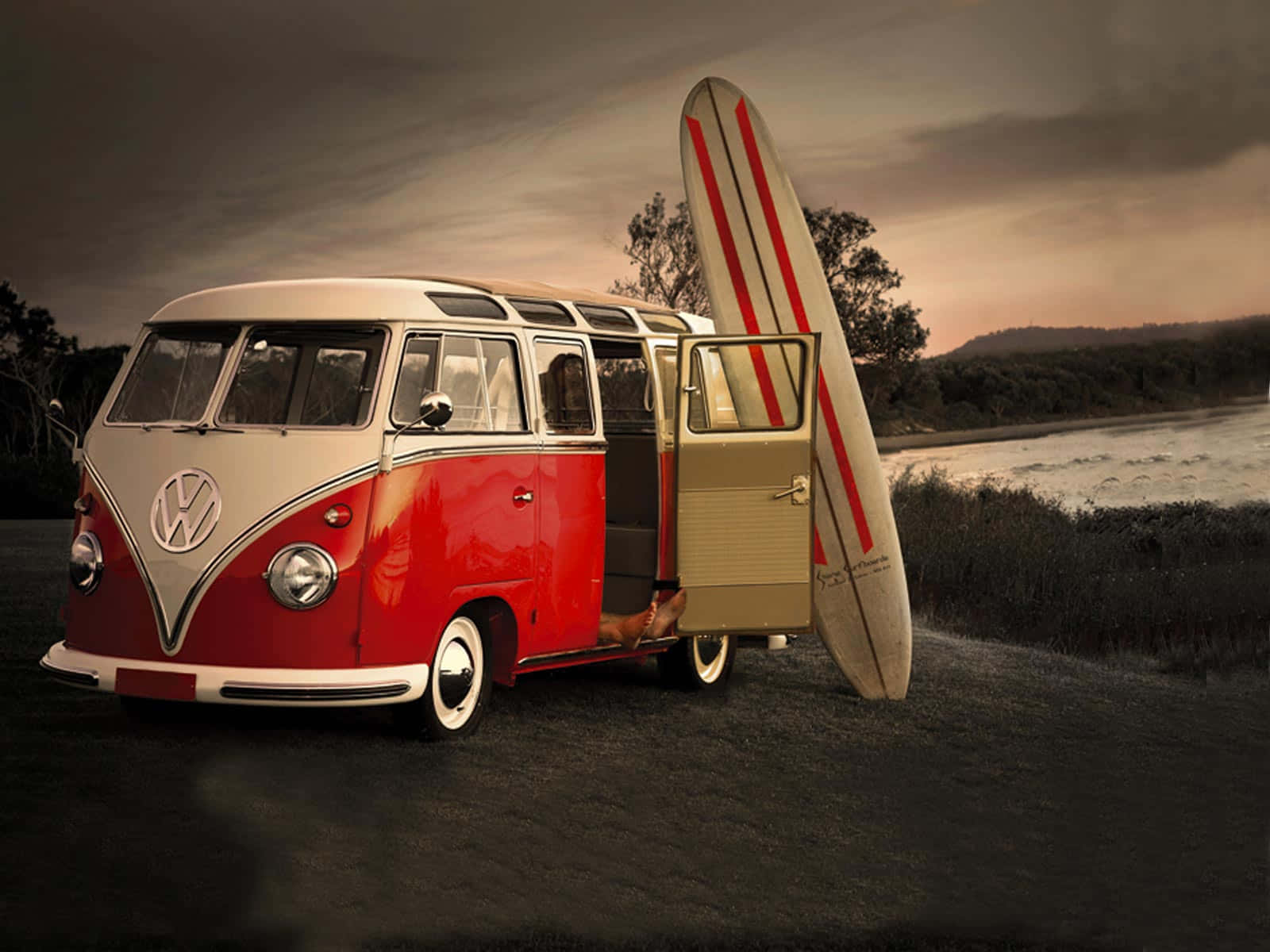 En VW-bus med en surfbræt på toppen Wallpaper