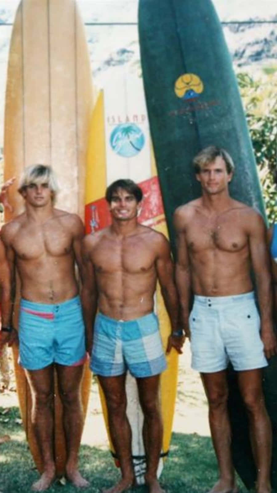 En gruppe mænd stående ved siden af ​​surfboards Wallpaper