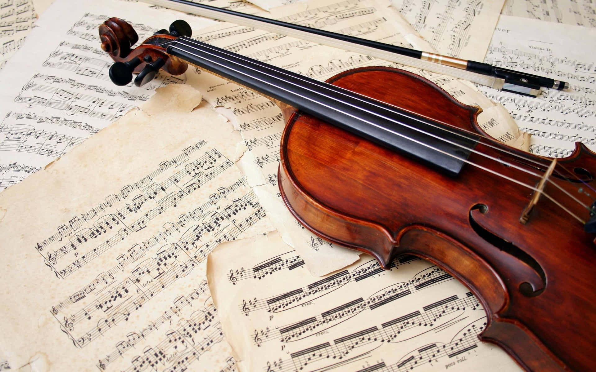 A Violin Resting On Music Sheets Wallpaper