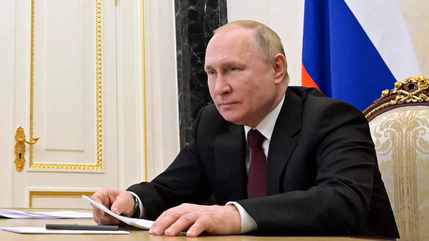 Vladimirputin Che Tiene Dei Documenti Mentre È Seduto. Sfondo
