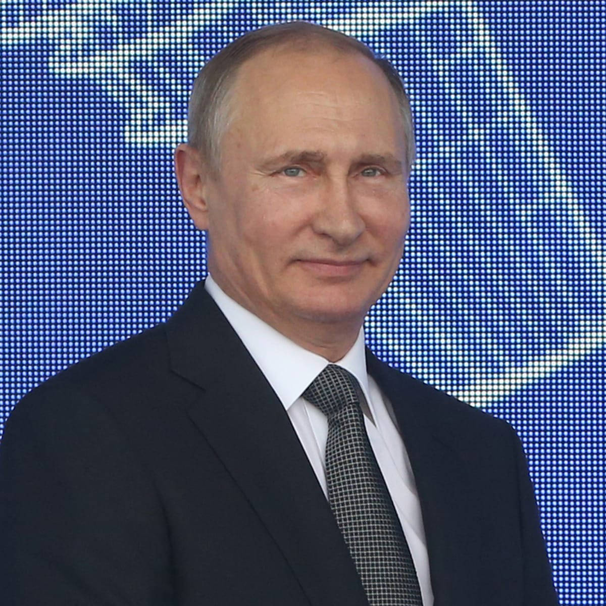 Vladimir Putin Smiling Against A Blue Screen Wallpaper