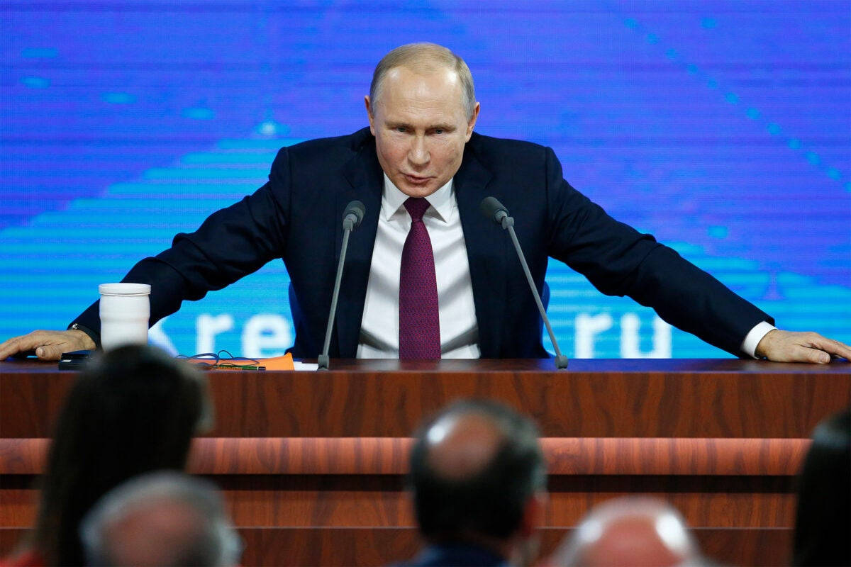 Vladimir Putin With Both Hands On Podium Wallpaper