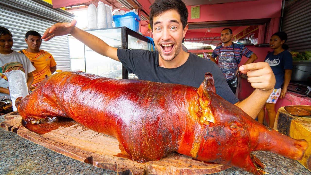 Enthusiastic Vlogger Experiencing Authentic Lechon Wallpaper